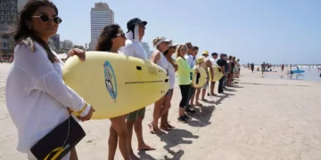 Manifestantes en la playa Gordon de Tel Aviv se unen a una cadena humana que se extiende desde la playa de Habonim hasta Rishon Lezion, para pedir la liberación de los rehenes retenidos desde el 7 de octubre por grupos terroristas en Gaza, el 19 de abril de 2024. (Dana Reany/Movimiento Pro-Democracia)