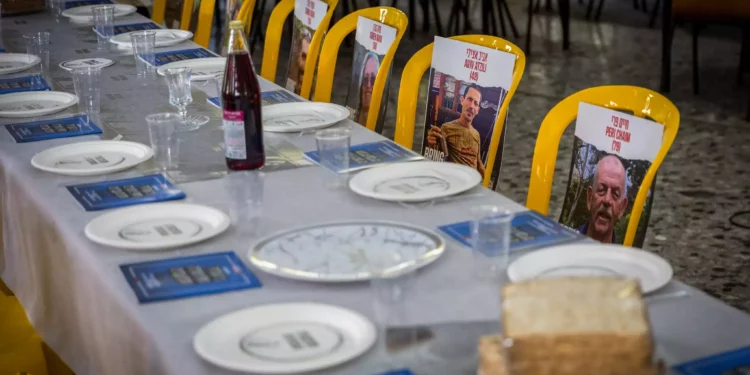 Fotos de rehenes del Kibbutz Nir Oz colocados en sillas y mesas durante un evento previo a Pesaj en el comedor del kibutz el 11 de abril de 2024. (Foto de Liron Moldovan/Flash90)