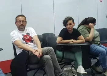 Victor Weinberger y Keren Flash hablan con los medios de comunicación en el Kibbutz Shefaim, donde viven actualmente ellos y cientos de otros residentes del Kibbutz Kfar Aza, el 3 de abril de 2024. (Maya Zanger-Nadis/Times of Israel)