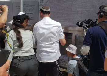Las familias encienden velas conmemorativas para sus seres queridos justo antes de las ceremonias de bar y bat mitzvah para los hijos de los soldados caídos de las FDI en el Muro Occidental el 3 de abril de 2024 (Maya Zanger-Nadis/Times of Israel)