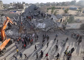 Rescatistas buscan supervivientes bajo los escombros de un edificio alcanzado en un ataque israelí nocturno en Rafah, en el sur de la Franja de Gaza, el 21 de abril de 2024 (MOHAMMED ABED / AFP)