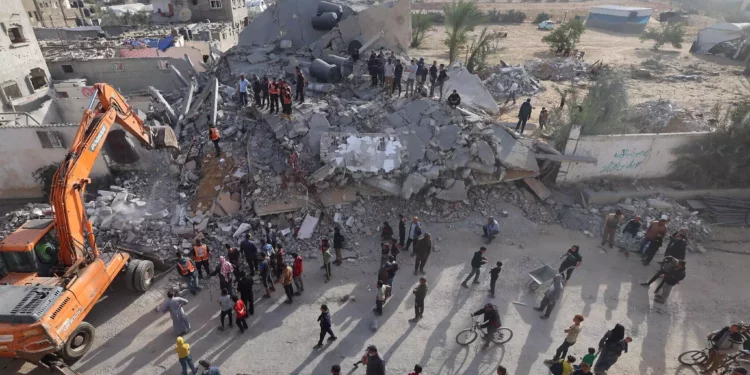 Rescatistas buscan supervivientes bajo los escombros de un edificio alcanzado en un ataque israelí nocturno en Rafah, en el sur de la Franja de Gaza, el 21 de abril de 2024 (MOHAMMED ABED / AFP)