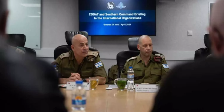 El jefe del Comando Sur de las FDI, mayor general Yaron Finkelman (derecha), y el jefe de COGAT, mayor general Ghassan Alian, se reúnen con representantes de organizaciones de ayuda humanitaria en el cuartel general del Comando Sur en Beersheba, el 10 de abril de 2024. (Fuerzas de Defensa de Israel)