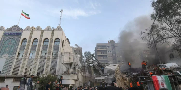 El personal de emergencia y de seguridad busca entre los escombros en el lugar de los ataques que impactaron en un edificio anexo a la embajada iraní en la capital de Siria, Damasco, el 1 de abril de 2024. (LOUAI BESHARA/ AFP)