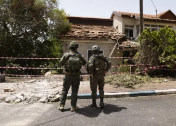 Soldados inspeccionando los daños a una sinagoga en la comunidad norteña de Dovev, después de que fuera alcanzada por cohetes disparados desde el Líbano, durante una gira de las FDI, el 27 de mayo de 2024. (Jalaa Marey/ AFP)
