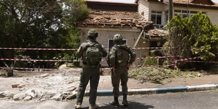Soldados inspeccionando los daños a una sinagoga en la comunidad norteña de Dovev, después de que fuera alcanzada por cohetes disparados desde el Líbano, durante una gira de las FDI, el 27 de mayo de 2024. (Jalaa Marey/ AFP)