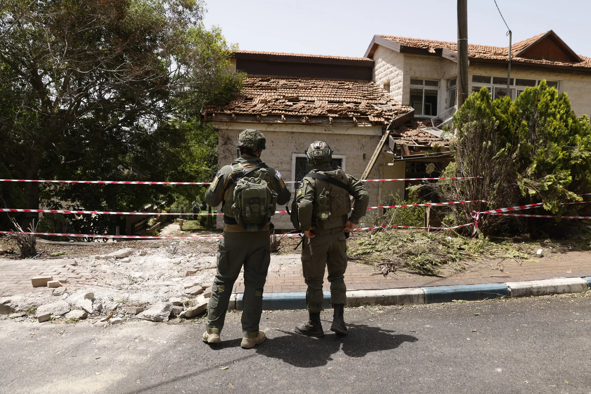 Soldados inspeccionando los daños a una sinagoga en la comunidad norteña de Dovev, después de que fuera alcanzada por cohetes disparados desde el Líbano, durante una gira de las FDI, el 27 de mayo de 2024. (Jalaa Marey/ AFP)
