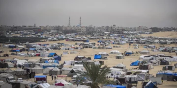 Palestinos desplazados por la guerra en curso en la Franja de Gaza caminan por un campamento improvisado en Rafah, el 10 de mayo de 2024. (AP Foto/Abdel Kareem Hana)