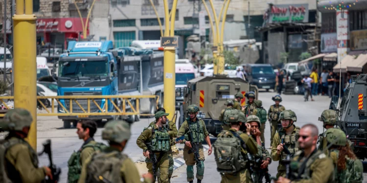 Fuerzas de seguridad israelíes vistas en la entrada de la ciudad de Hebrón, en Cisjordania, después del mortal ataque a tiros en la Ruta 60, el 21 de agosto de 2023. (Chaim Goldberg/Flash90)