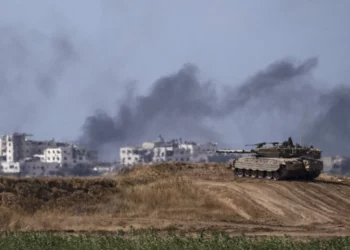 Con el telón de fondo del humo que se eleva hacia el cielo tras una explosión en la Franja de Gaza, un tanque israelí permanece cerca de la frontera entre Israel y Gaza, visto desde el sur de Israel, el lunes 13 de mayo de 2024. (AP/Leo Correa)