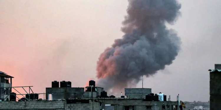 El humo se eleva por encima de los edificios durante un ataque israelí en la madrugada en Rafah, en el sur de la Franja de Gaza, el 11 de mayo de 2023. (AFP)