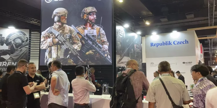 La gente se reúne alrededor del stand de Colt, en exhibición en la exposición Defense Services Asia (DSA) en Kuala Lumpur, Malasia, el martes 7 de mayo de 2024. (AP Foto/Syawalludin Zain)