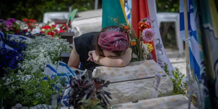 Una mujer llora en la tumba de un soldado muerto durante la guerra, en el cementerio militar del Monte Herzl en Jerusalén, el 10 de mayo de 2024 (Chaim Goldberg/Flash90)