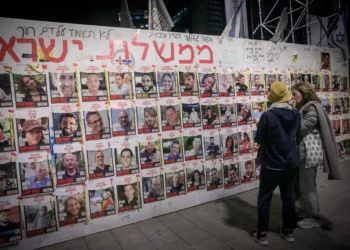 People walk by photographs of Israelis still held hostage by Hamás terrorists in Gaza. May 5, 2024. (Miriam Alster/Flash90)