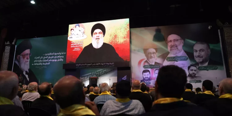 People gather to listen to a televised speech by Hezbolá Secretary general Hassan Nasrallah during a rally to mourn the recent death of the Iranian president Ebrahim Raisi and his entourage, killed in a helicopter accident, in Beirut's southern suburbs on May 24, 2024. (Anwar Amro/AFP)
