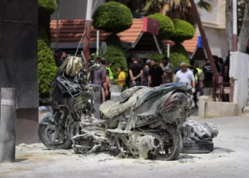 A charred motorcycle is seen after an Israeli strike outside Salah Ghandour Hospital, background, in Bint Jbeil town, south Lebanon, May 27, 2024. (AP Photo/Mohammad Zaatari)