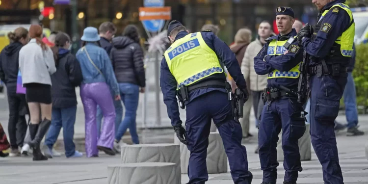 La policía monta guardia mientras la gente hace cola para el segundo ensayo general de la primera semifinal en el Festival de la Canción de Eurovisión en Malmö, Suecia, el lunes 6 de mayo de 2024. (AP Foto/Martin Meissner)
