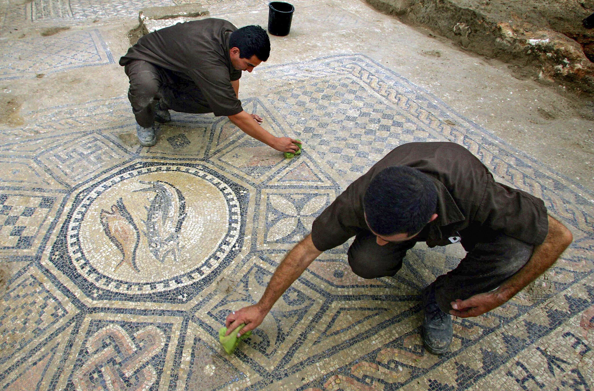 Los prisioneros trabajan en un piso decorado de casi 1.800 años de antigüedad de una sala de oración paleocristiana descubierta en la prisión de Megiddo por arqueólogos israelíes el 6 de noviembre de 2005. (Ariel Schalit/AP)