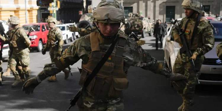 Un soldado hace un gesto a los periodistas para que abandonen la Plaza Murillo mientras los soldados se reúnen frente al palacio presidencial en la Plaza Murillo en La Paz, Bolivia, el miércoles 26 de junio de 2024. (Foto AP/Juan Karita)