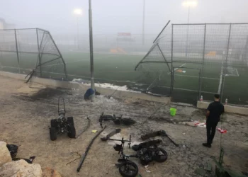 Un hombre se encuentra cerca de una puerta dañada después de un ataque con cohetes de Hezbolá en un campo de fútbol que mató a 12 niños en Majdal Shams el 28 de julio de 2024 (Menahem Kahana / AFP)