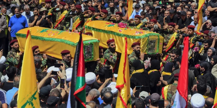 Los dolientes llevan los ataúdes de los terroristas de Hezbolá Mohammed Hussein Qassem y Abbas Ahmed Soror, quienes fueron asesinados por un ataque israelí, durante su procesión fúnebre en la aldea de Aita al-Shaab, en el sur del Líbano, el sábado 29 de junio de 2024. (Foto AP/Mohammed Zaatari)