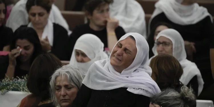 Mujeres drusas lloran cerca de los ataúdes de sus seres queridos después de un ataque con cohetes de Hezbolá en un campo de fútbol que mató a 12 niños en Majdal Shams el 28 de julio de 2024 (Foto AP/Leo Correa)