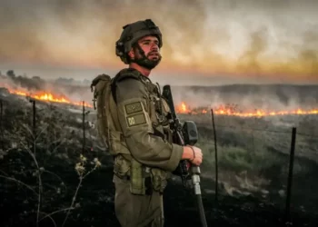 Israeli Security forces try to extinguish a fire near the scene of where a rocket fired from Lebanon hit a car and critically injured two people near Nafah Junction, in the Golan Heights, July 9, 2024.