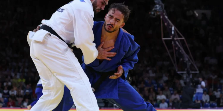 El israelí Baruch Shmailov y el marroquí Abderrahmane Boushita (azul) compiten en el combate de dieciseisavos de final de judo masculino de -66 kg de los Juegos Olímpicos de París 2024 en el Champ-de-Mars Arena, en París, el 28 de julio de 2024. (Jack GUEZ / AFP)