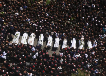 Los dolientes rodean los ataúdes de 10 de los 12 niños muertos en un ataque con cohetes de Hezbolá en Majdal Shams el 28 de julio de 2024 (Menahem Kahana / AFP)