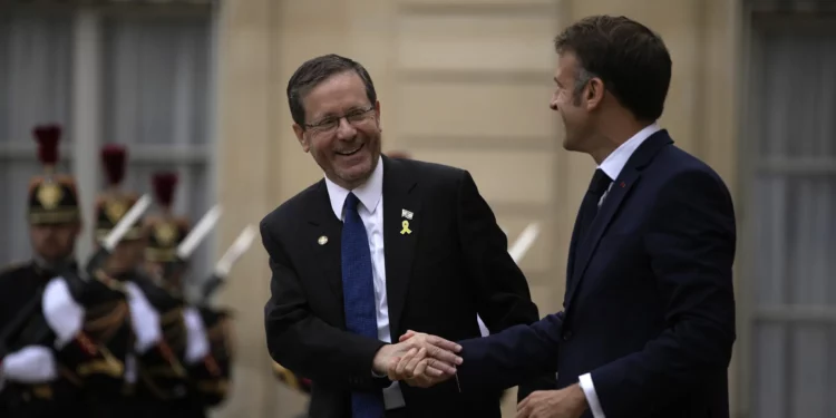 El presidente francés, Emmanuel Macron (derecha), estrecha la mano del presidente israelí, Isaac Herzog, después de su reunión en el Palacio del Elíseo, antes de la ceremonia de apertura de los Juegos Olímpicos de Verano de 2024, el viernes 26 de julio de 2024, en París, Francia. (Foto AP/Louise Delmotte)