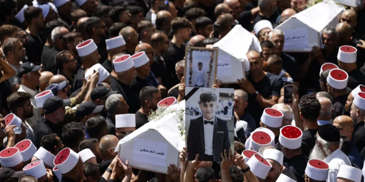 Los dolientes llevan los ataúdes de 10 de los 12 niños muertos en un ataque con cohetes de Hezbolá en Majdal Shams el 28 de julio de 2024 el 28 de julio de 2024 (Jalaa MAREY / AFP)