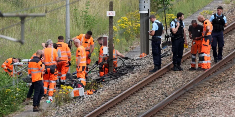 Los empleados de la SNCF y los gendarmes franceses inspeccionan el lugar de un presunto ataque a la red ferroviaria de alta velocidad en Croiselles, en el norte de Francia, el 26 de julio de 2024. (Foto de Denis CHARLET / AFP)