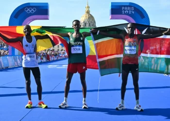 El etíope ganador Tamirat Tola (centro), el belga Bashir Abdi (izq.), segundo clasificado, y el keniano Benson Kipruto, tercero, celebran después del maratón masculino de la prueba de atletismo de los Juegos Olímpicos de París 2024 en Inválidos, en París, el 10 de agosto de 2024. (Andrej Isakovic/AFP)