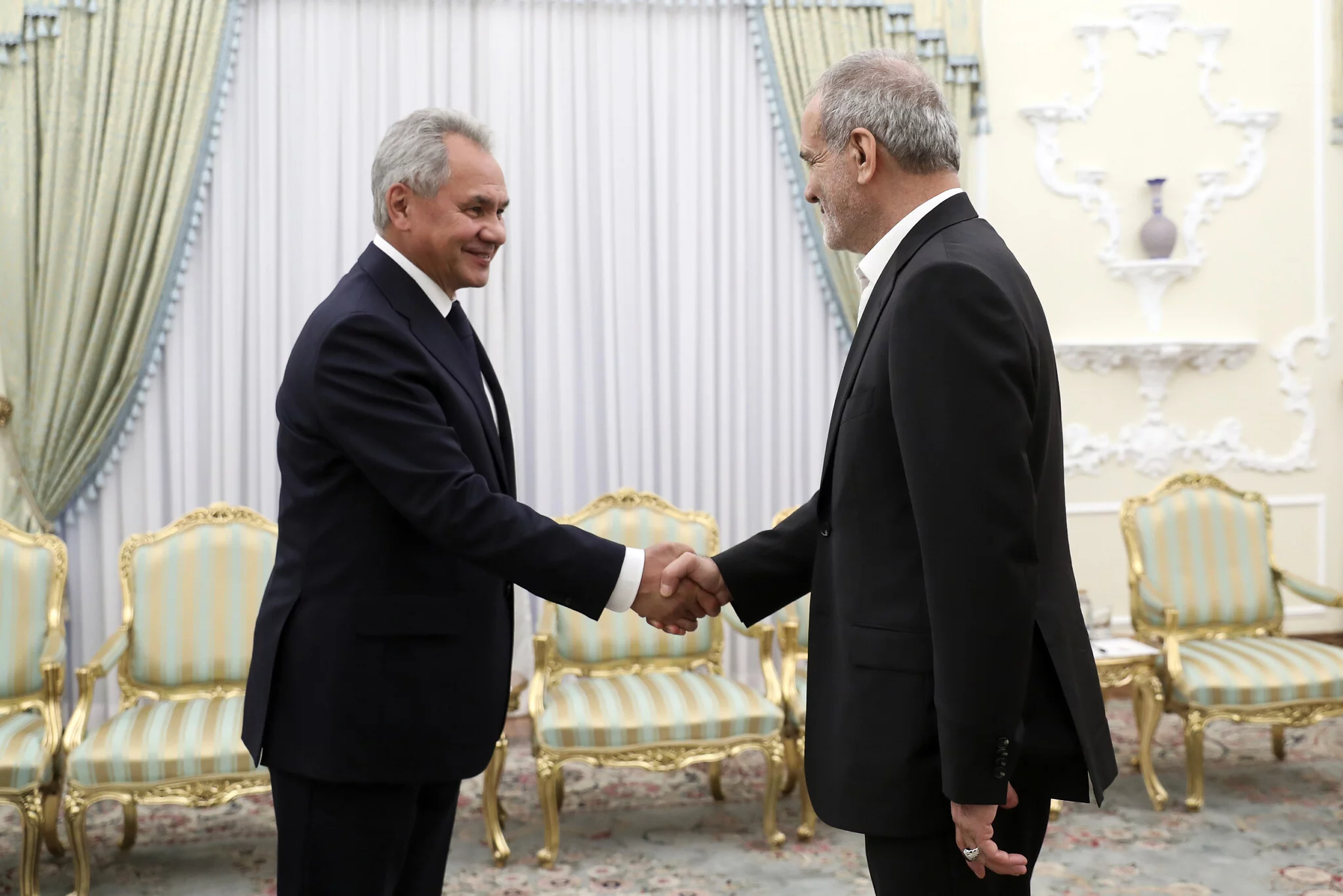 El presidente iraní, Masoud Pezeshkian, a la derecha, estrecha la mano del secretario del Consejo de Seguridad de Rusia, Sergei Shoigu, al comienzo de su reunión en su oficina en Teherán, Irán, el 5 de agosto de 2024. (Oficina de la Presidencia iraní vía AP)