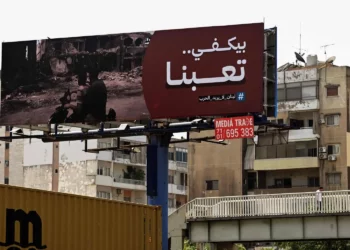 Un enorme cartel en una calle de Beirut incluye una frase que pide el fin de la guerra (AFP)