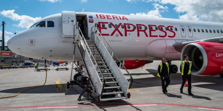 Los pasajeros desembarcan de un avión de la aerolínea de bajo coste española Iberia Express en el aeropuerto Willy Brandt de Berlín Brandeburgo (BER) en Schoenefeld, al sureste de la capital alemana, el 16 de julio de 2022. (John MacDougall / AFP)