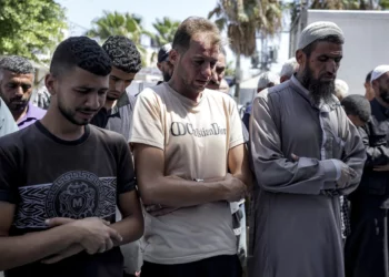 Mohammad Abu Al-Qumsan (centro) reza junto a los cadáveres de sus hijos gemelos de cuatro días de nacidos, asesinados en la Franja de Gaza, en un hospital de Deir al-Balah, el 13 de agosto de 2024. (Foto AP/Abdel Kareem Hana)