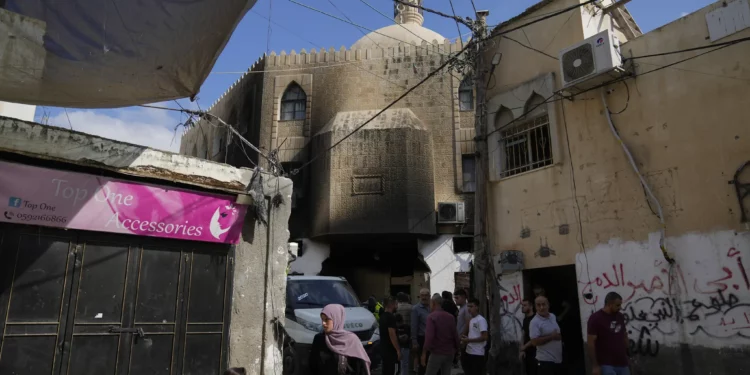 Palestinos se encuentran afuera de una mezquita dañada luego de una operación militar israelí en el campo de refugiados de Al-Faraa, en Judea y Samaria, el jueves 29 de agosto de 2024. (Foto AP/Nasser Nasser)