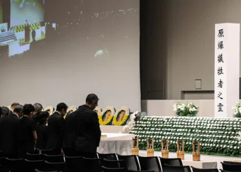 Los asistentes observan un momento de silencio en el momento del bombardeo atómico de 1945 a las 11:02 am mientras celebran una ceremonia en memoria de la paz en una instalación cubierta debido a la aproximación del tifón Khanun en Nagasaki, prefectura de Nagasaki, el 9 de agosto de 2023 (JIJI Press / AFP)