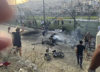 Los residentes se apresuran a ayudar a los niños heridos momentos después de que un cohete impactara en un campo de fútbol en la ciudad norteña drusa de Majdal Shams, en los Altos del Golán, el 27 de julio de 2024. (Foto AP/Hassan Shams)