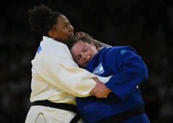 Erdenebayar Batzaya de Mongolia y Sagi Muki (azul) de Israel compiten en el combate de dieciseisavos de final del equipo mixto de judo de los Juegos Olímpicos de París 2024 en el Champ-de-Mars Arena, en París, el 3 de agosto de 2024. (Jack Guez/AFP)