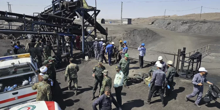 En esta fotografía difundida por la Media Luna Roja de Irán, personal de rescate, agentes de policía y otras personas se reúnen en torno a una mina de carbón donde una fuga de metano provocó una explosión el sábado, en Tabas, a unas 335 millas (540 kilómetros) al sureste de la capital, Teherán, Irán, el 22 de septiembre de 2024. (Sociedad de la Media Luna Roja de Irán, vía AP)