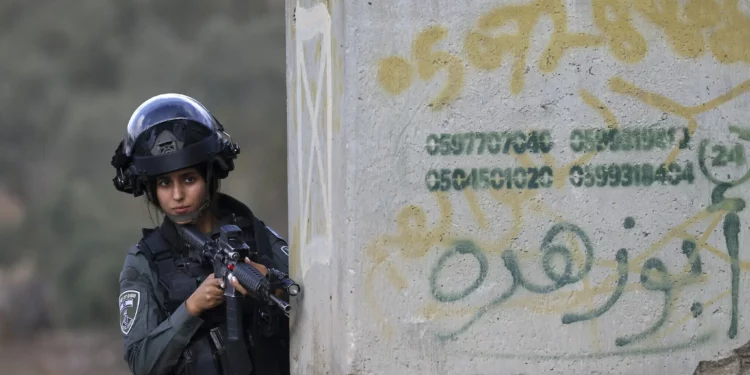 Una agente de la policía fronteriza toma posición en la zona de un ataque con disparos cerca del cruce de Tarqumiya al norte de Hebrón en Judea y Samaria el 1 de septiembre de 2024. (HAZEM BADER / AFP)