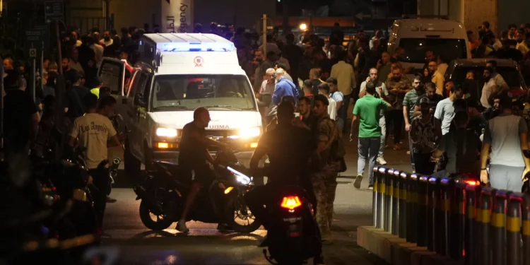 Varias personas se reúnen alrededor de una ambulancia que transportaba a heridos cuyo buscapersonas portátil explotó, en la entrada de emergencia del hospital de la Universidad Americana en Beirut, Líbano, el 17 de septiembre de 2024, después de un ataque, atribuido a Israel, dirigido contra combatientes de Hezbolá. (Foto AP/Hassan Ammar)