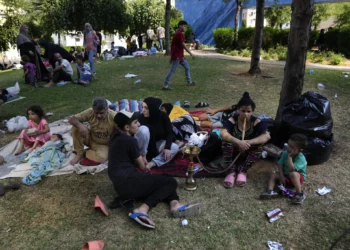 Personas que huyeron del suburbio sur de Beirut en medio de los continuos ataques aéreos israelíes contra objetivos de Hezbolá, sentadas en un parque en el centro de Beirut, Líbano, el 28 de septiembre de 2024. (Foto AP/Hussein Malla)