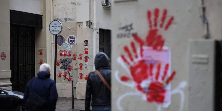 Una imagen muestra grafitis de manos rojas pintados en las paredes de los edificios de la calle Sainte-Croix de la Bretonnerie, en la zona donde anteriormente el monumento al Holocausto fue vandalizado con las mismas huellas de manos rojas en París, el 14 de mayo de 2024. (Antonin Utz/ AFP)