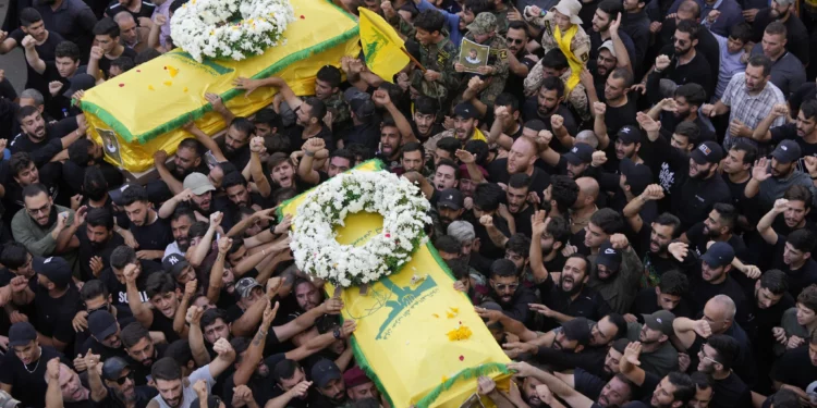 Miembros de Hezbolá llevan los ataúdes de dos de sus camaradas que murieron el miércoles cuando explotó un dispositivo portátil durante una procesión fúnebre en los suburbios del sur de Beirut, el jueves 19 de septiembre de 2024. Israel ha sido culpado por los ataques. (Foto AP/Hussein Malla)