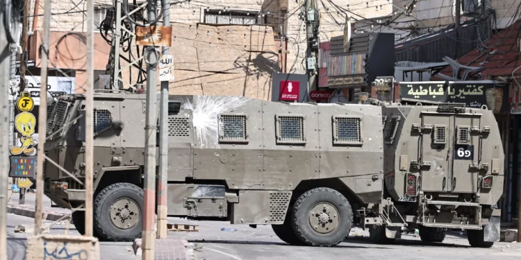 Ambulancias de la Media Luna Roja Palestina y vehículos del ejército israelí durante una incursión militar israelí en Qabatiyah, en el norte de Cisjordania, el 19 de septiembre de 2024. (Zain JAAFAR / AFP)