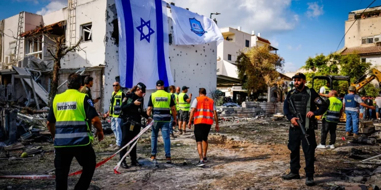 Trabajadores de rescate israelíes en el lugar donde un misil lanzado desde el Líbano impactó casas y automóviles en Kiryat Bialik, en el norte de Israel, el 22 de septiembre de 2024. (Chaim Goldberg/Flash90)