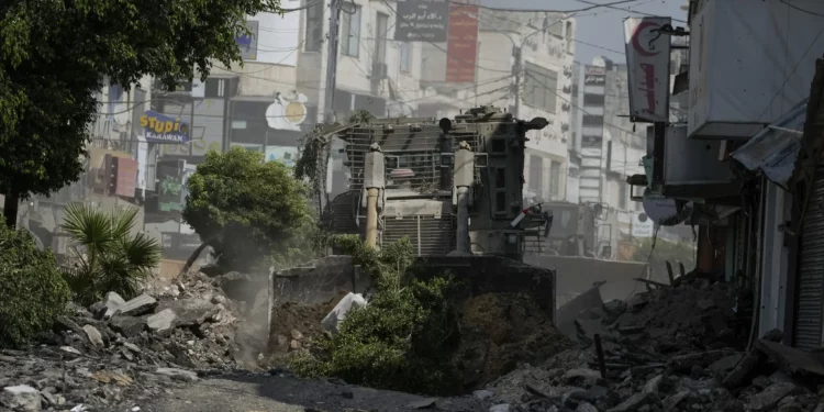 Una excavadora militar israelí destruye una carretera llena de escombros durante una redada del ejército en Jenín, Judea y Samaria, el 2 de septiembre de 2024. (Foto AP/Majdi Mohammed)